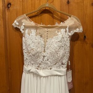 NWT Ivory (white) wedding dress. Size 2. Mesh neck and back, cap sleeve.